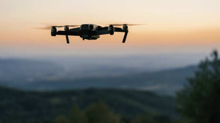 Drone flying at sunset with blurred landscape in the background